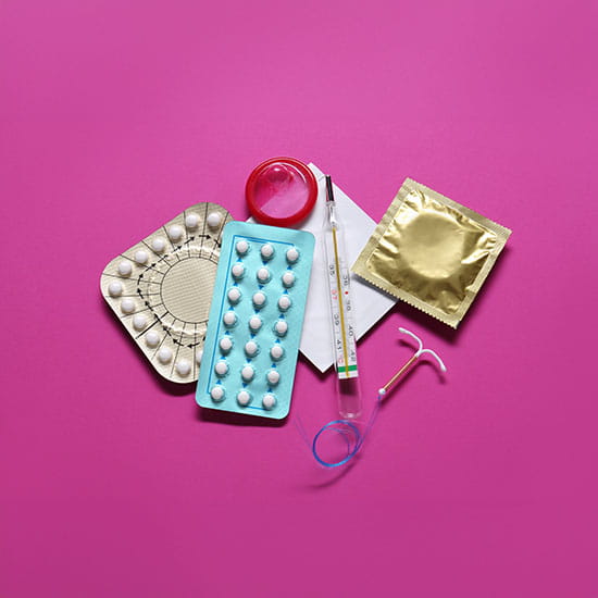 Different birth control methods on a pink background