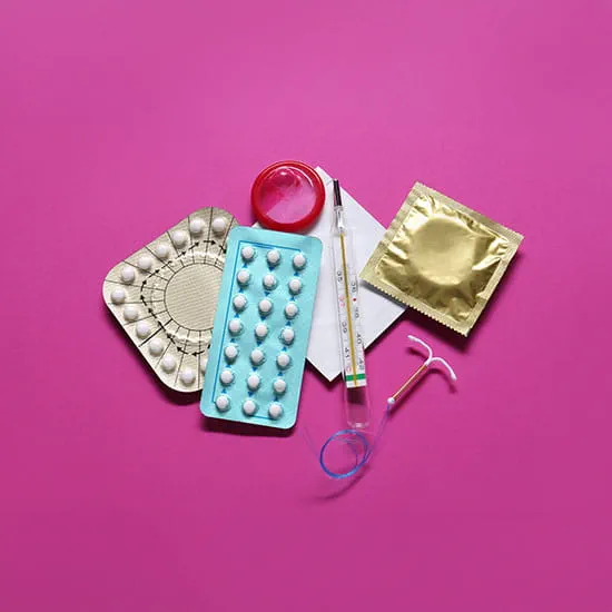 Different birth control methods on a pink background