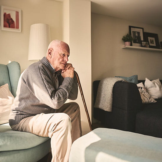 Elderly man sitting alone at home