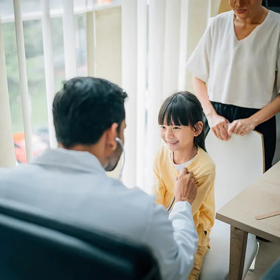 Doctor examining a little girl with a stethoscope