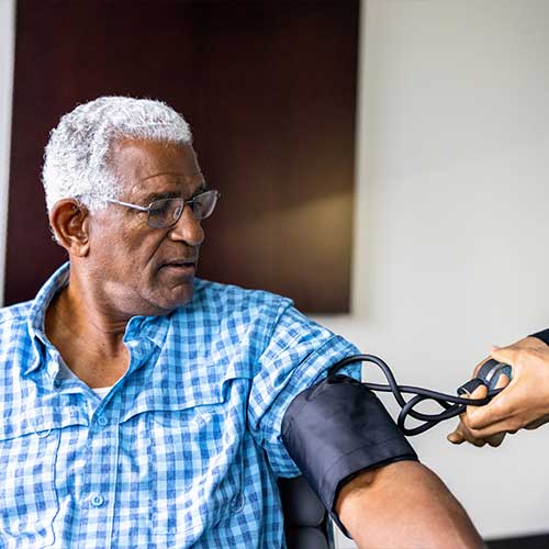 A nurse meeting with a senior black male patient