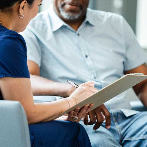 Close up of female healthcare professional reading forms to her patient
