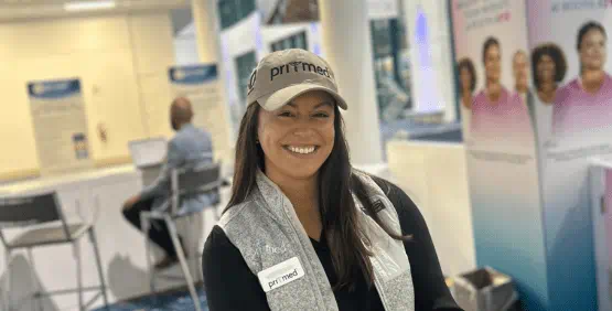 Pri-Med employee wearing the tan 30th anniversary ball cap with Pri-Med logo.