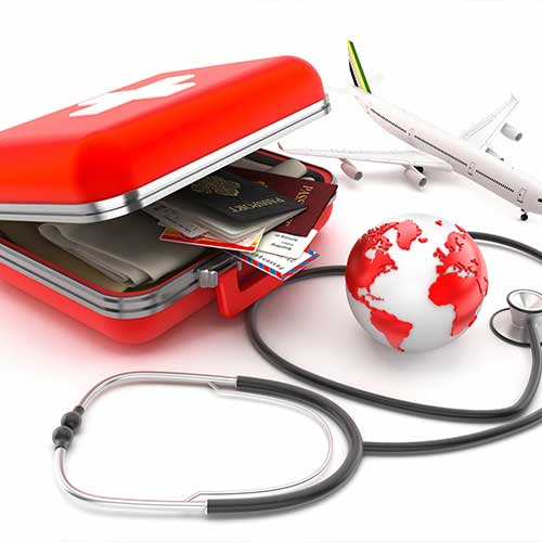 First-aid kit designed as a suitcase with passports, plane tickets and clothes inside, stethoscope and globe isolated on white.