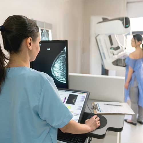 Unrecognizable nurse taking a mammogram exam to an adult patient at the hospital