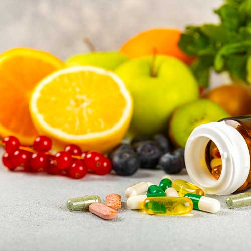 Variety of vitamin tablets in a jar on a texture background.