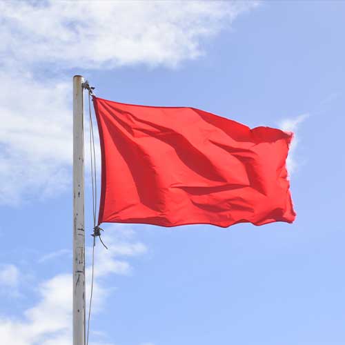 Red flag warning of danger on the beach