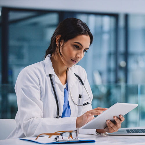 Clinician on tablet in a medical setting