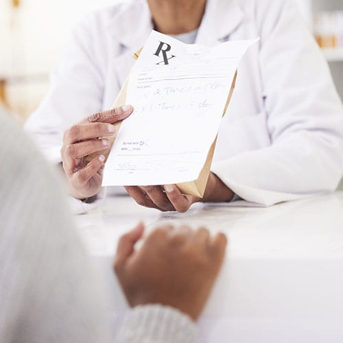 Clinician showing a prescription to a patient