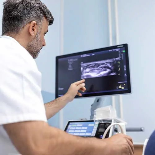 At the medical clinic, Caucasian male doctor doing the doppler ultrasound test evaluation of arteries and veins on a female patient