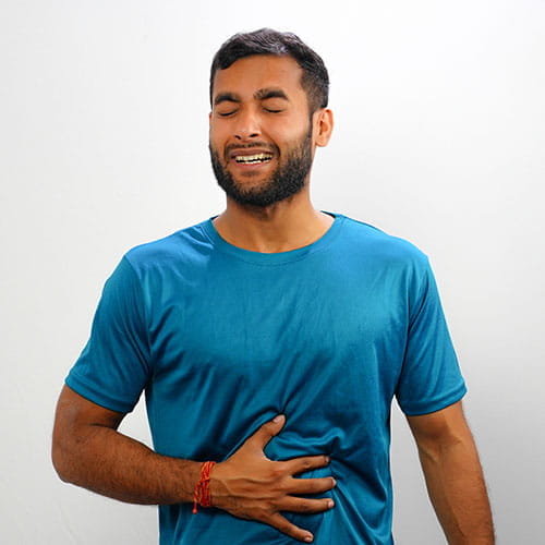 Man wincing and holding his hand on his stomach