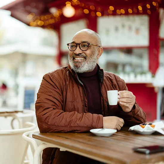 older man sitting at table drinking coffee