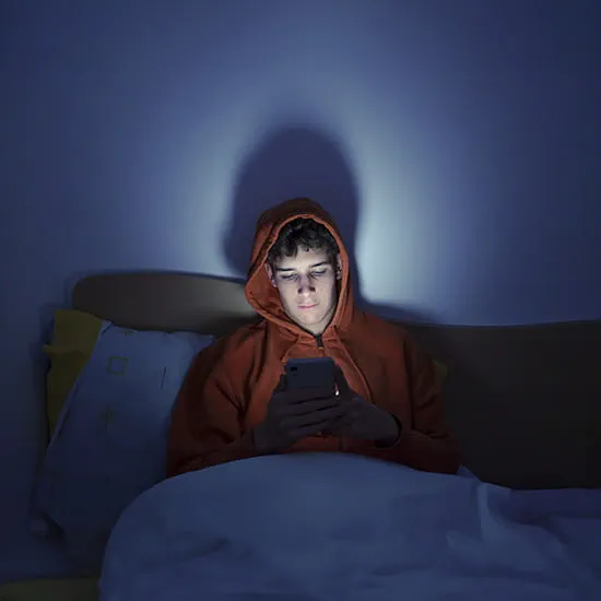 man in bed using his phone
