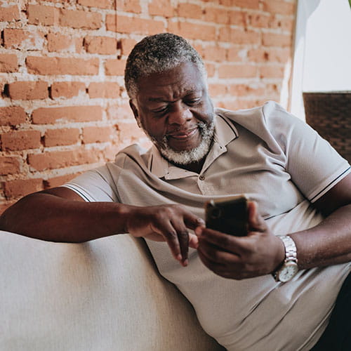 Man using his phone on a couch