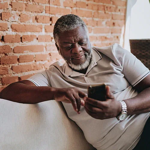 Man using his phone on a couch