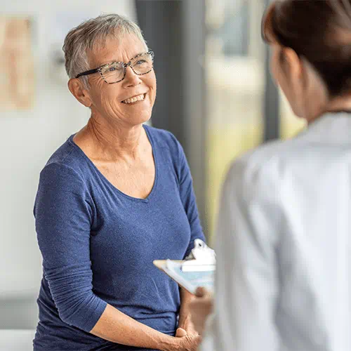 elderly patient sitting and speaking with doctor