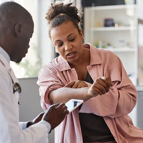 Woman showing her arm to a doctor