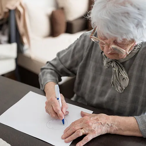 Elderly woman writing on a piece of paper