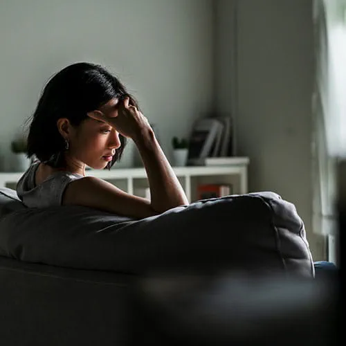Woman sitting on a couch looking sad