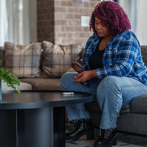 Woman checking her blood sugar levels at home
