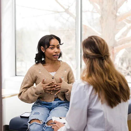 Patient meeting with a doctor and explaining her symptoms