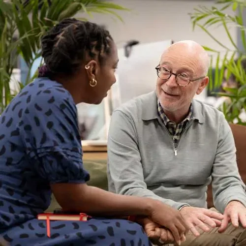 Man and woman sitting down talking towards each other