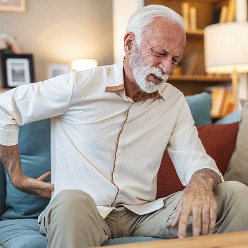 Senior old elderly man grandfather touching his back, suffering from backpain, sciatica, sedentary lifestyle concept. Spine health problems. Healthcare, insurance.