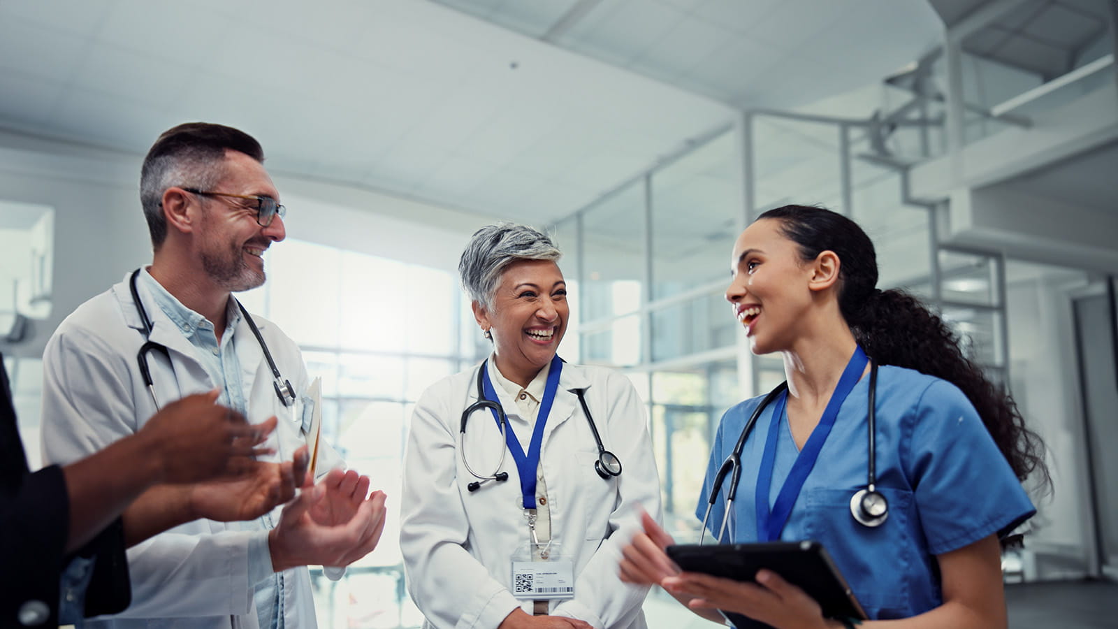 Doctors and a nurse having a conversation in the atrium of a hospital