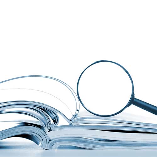 Searching, opened magazines and magnifier glass, side view, isolated white