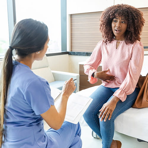 Woman describing abdominal pain to a doctor