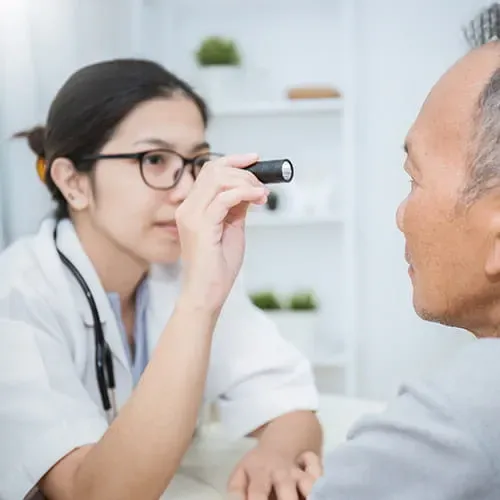 Doctor shining a light in a patient's eyes