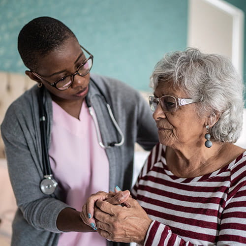 Home caregiver helping a senior woman