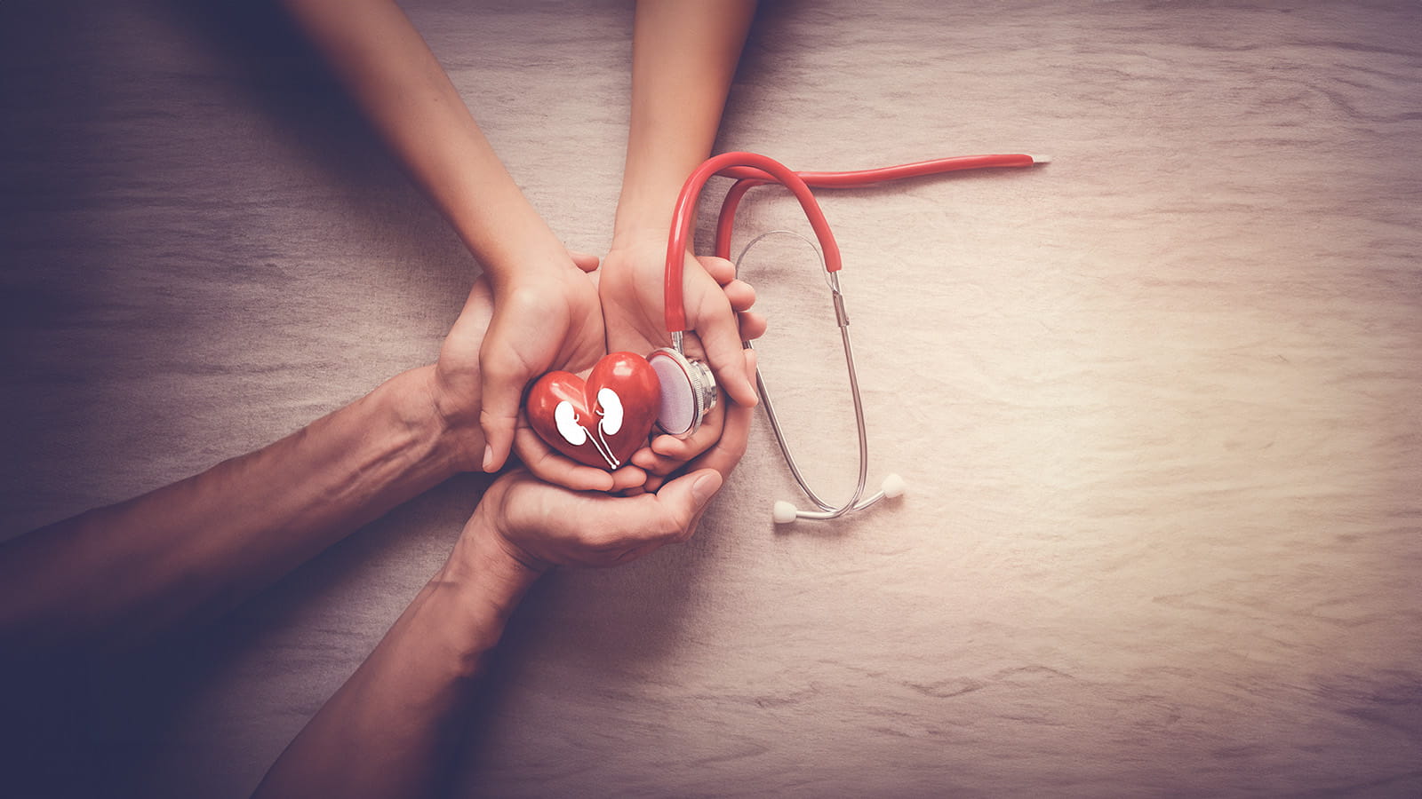 Hands holding red heart with stethoscope