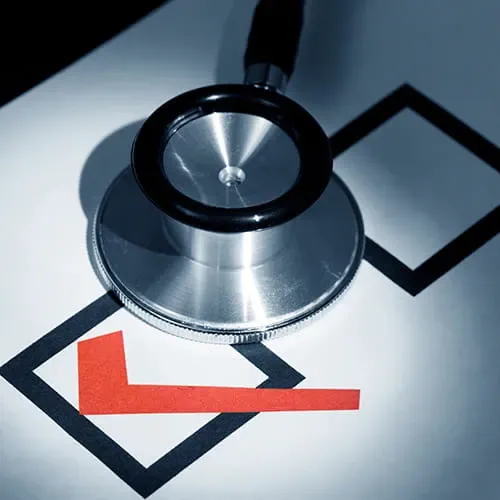Stethoscope resting on a paper with a check mark