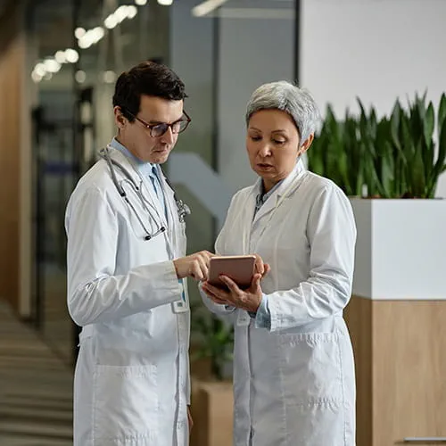 Doctors looking at a tablet in a hallway