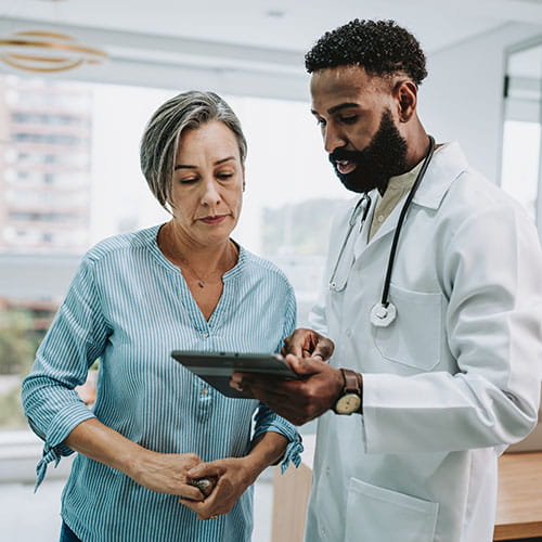 Doctor talking to patient while holding tablet