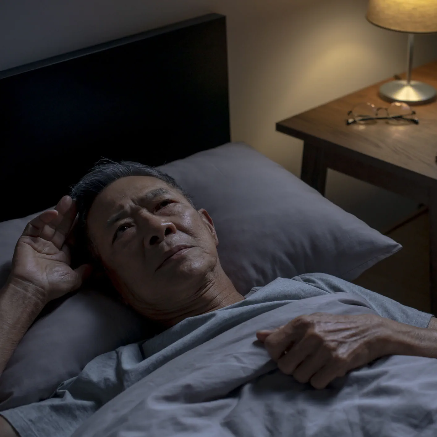 Man laying in bed wide awake