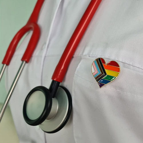 Close up of a doctor in white coat with stethoscope and LGBT badge