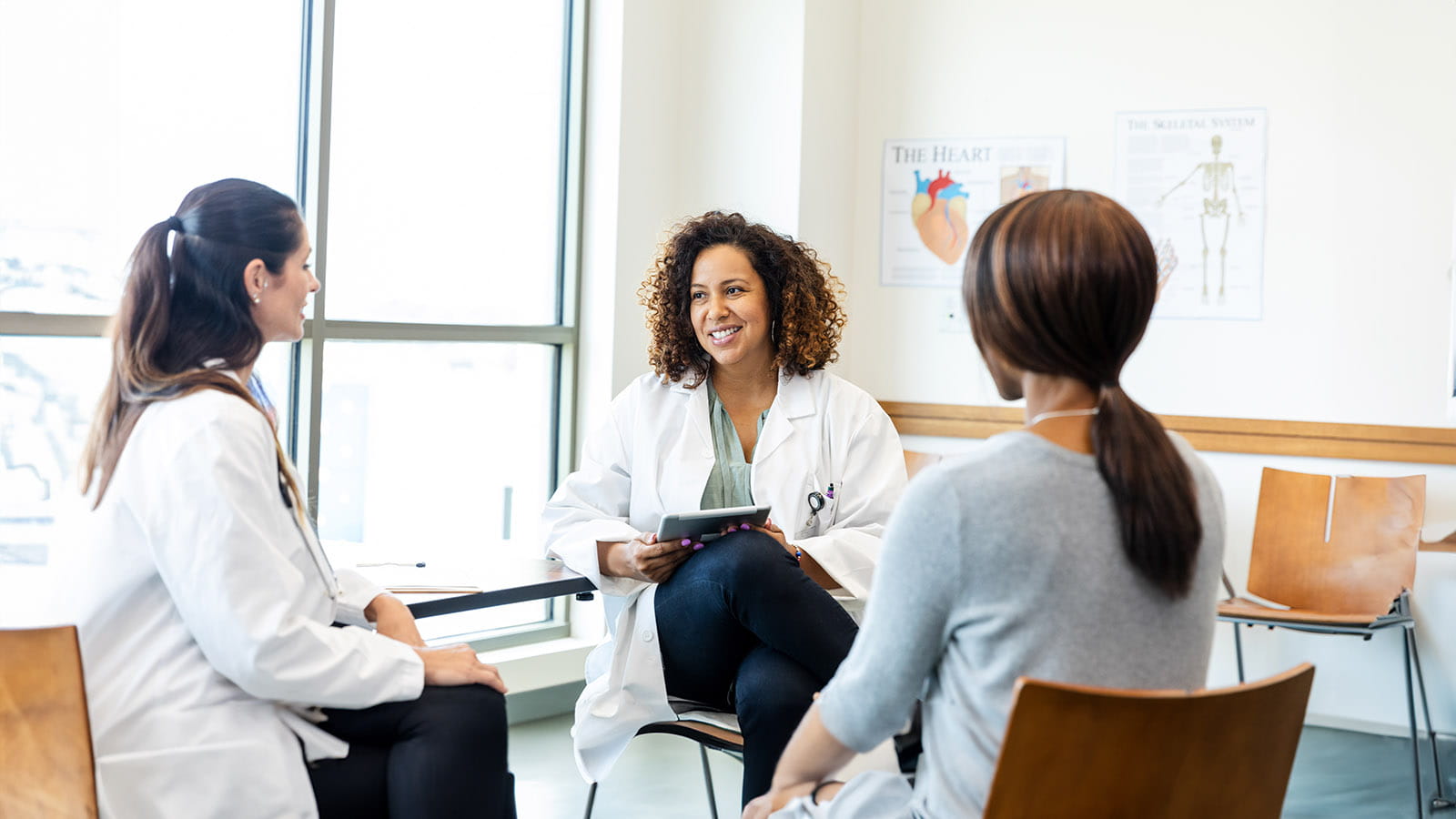 Doctors and a patient having a conversation in a medical setting