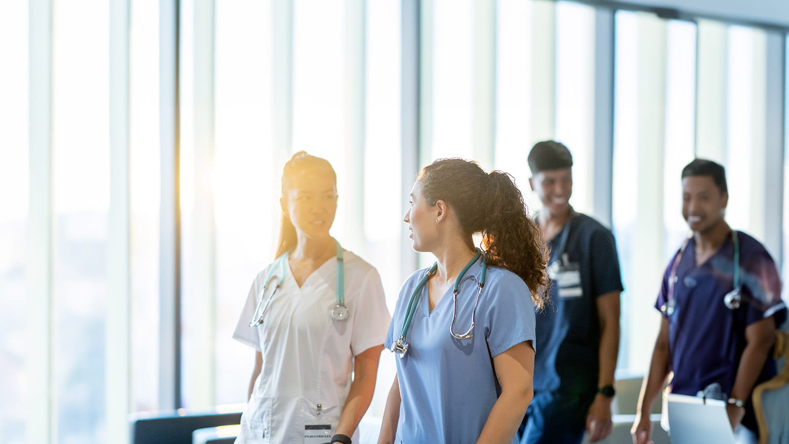 Medical workers conversing while walking in a hallway