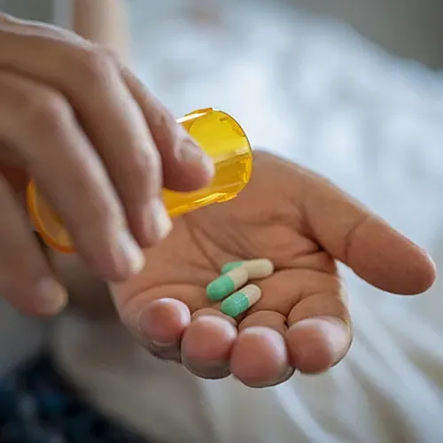 Close up of someone's hands holding pills
