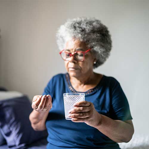 Senior woman taking medicines at home