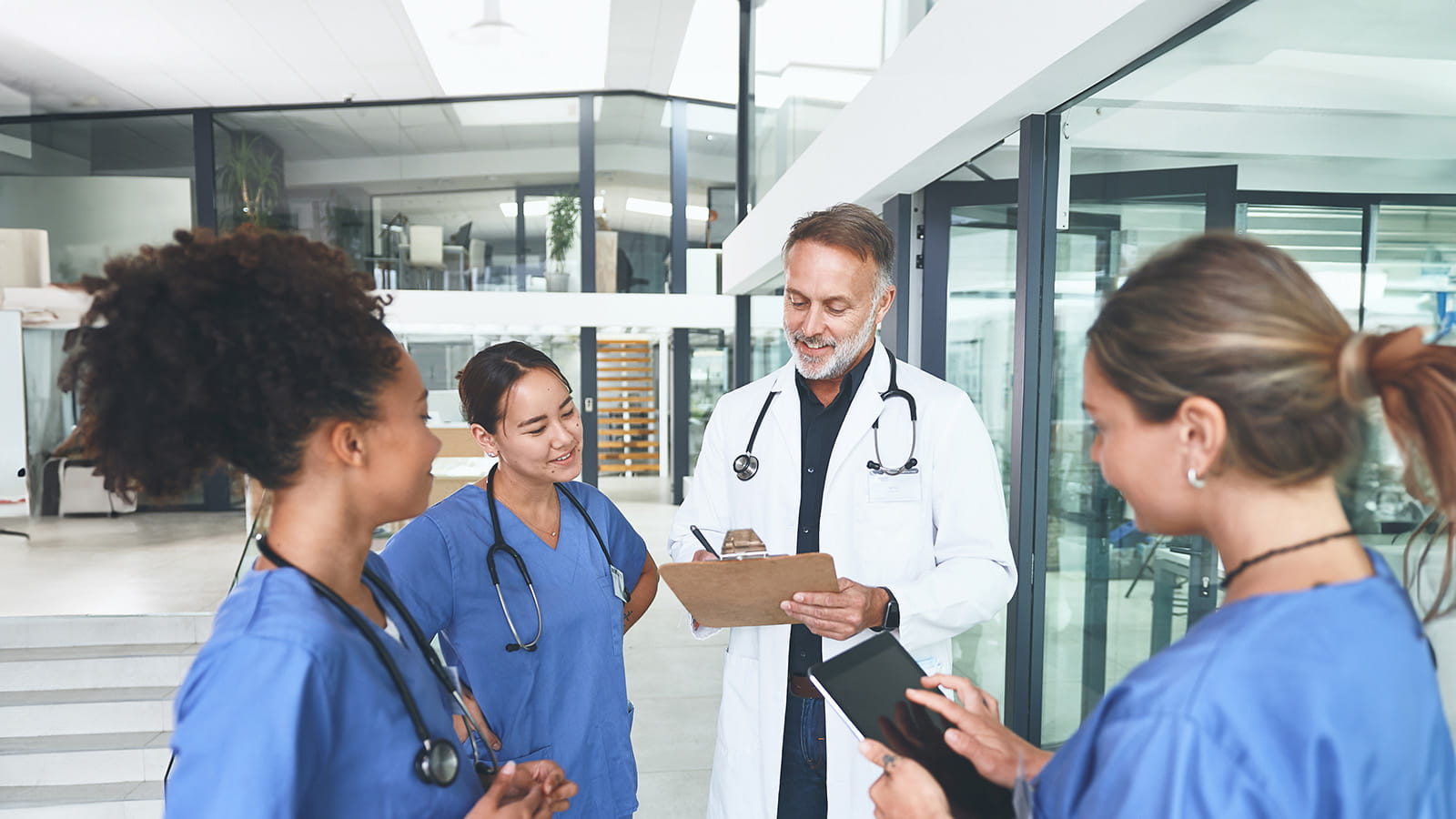 Doctor standing with his nurses and having a discussion in a clinic.
