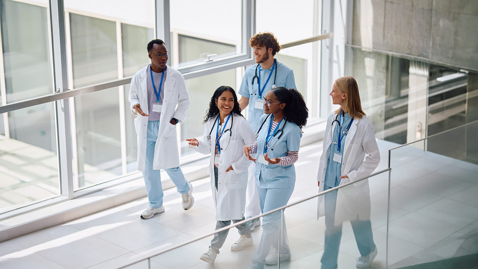 Clinicians walking on a bridge in a hospital