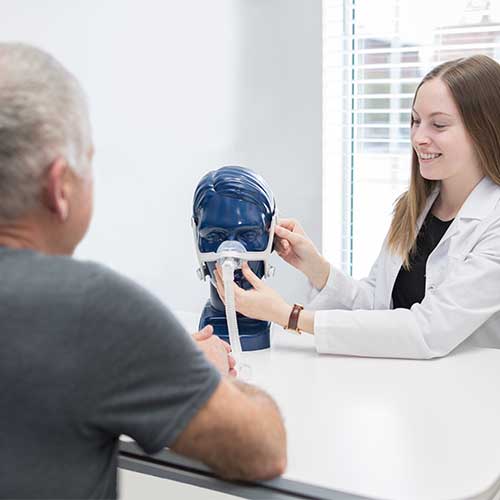 Pharmacist Showing a Patient How to Use Medical Equipment