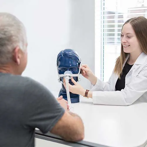 Pharmacist Showing a Patient How to Use Medical Equipment