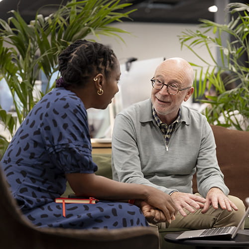 Man talking to a woman in front of a computer