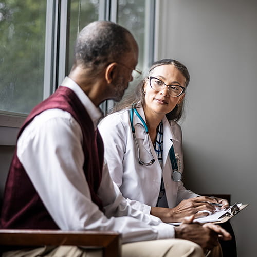 Doctor sitting with an older male patient