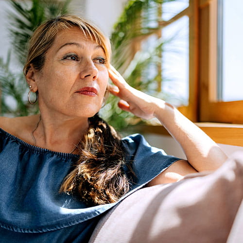 Woman sitting on a couch looking out a window