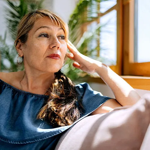 Woman sitting on a couch looking out a window